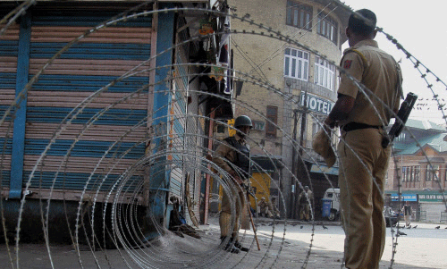 A security jawan keeping vigil during curfew in Srinagar on Friday. Authorities imposed curfew in the wake of protests after four people died in BSF firing on Thursday in Gool village of Ramban district. PTI Photo