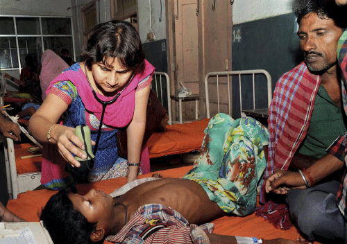 A doctor checks a school child who fell ill after consuming contaminated mid-day meal, at Patna Medical College & Hospital in Patna on Thursday. PTI Photo