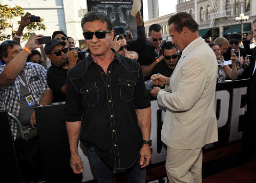 Sylvester Stallone, left, and Arnold Schwarzenegger arrive at the 'Escape Plan' special screening on Day 2 of Comic-Con International on Thursday, July 18, 2013 in San Diego, California. AP Photo.