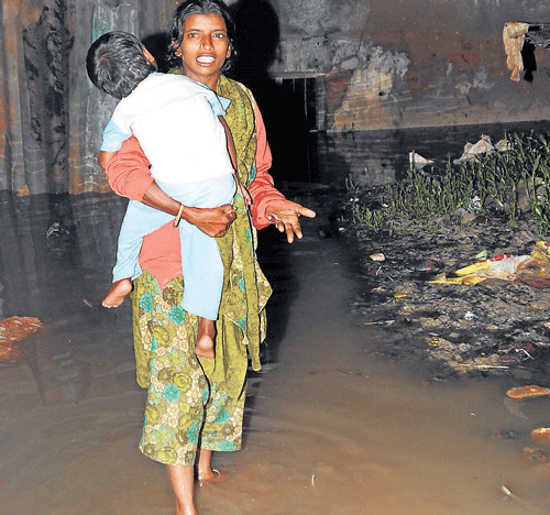This woman and her child from DJ Halli had to endure the full force of the rainwater mixed with sewage inundating the roads, as the stormwater drains are clogged.