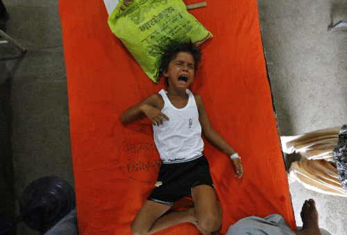 Khushi Kumari, who is sick, cries in pain as she lies on a bed inside a hospital after she consumed contaminated meals given to children at a school on Tuesday, in the eastern Indian city of Patna July 18, 2013. The Indian government announced on Thursday it would set up an inquiry into the quality of food given to school pupils in a nationwide free meal scheme after at least 23 children died in one of the deadliest outbreaks of mass poisoning in years. REUTERS