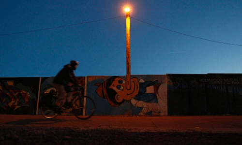 A cyclist passes a mural of Pinocchio located in front of a street light at Lansdowne Park in Ottawa. REUTERS
