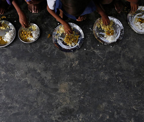 Schoolchildren eat their free mid-day meal, distributed by a government-run primary school at Brahimpur village in Chapra district of the eastern Indian state of Bihar July 19, 2013.
