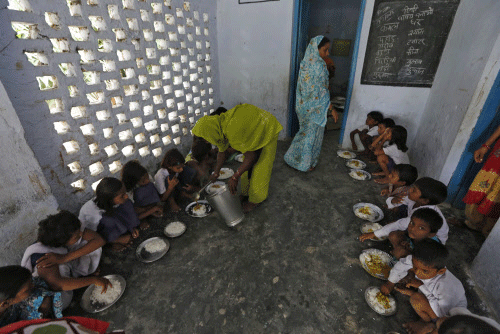 A cook serves the free mid-day meal, distributed by a government-run primary school, to children in Chapra district Reuters
