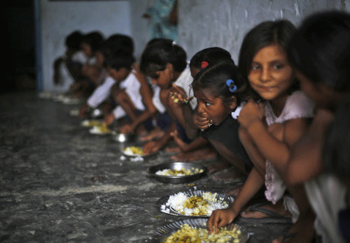 School children eat their free mid-day meal, distributed by a government-run primary school, at Brahimpur village in Chapra Reuters Image
