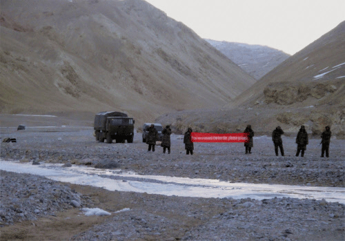 FILE- In this May 5, 2013 file photo, Chinese troop hold a banner which reads, 'You've crossed the border, please go back,' in Ladakh, India. Officials from India and China have begun talks to resolve a longstanding border dispute against the backdrop of recent flare-ups of tension between the two Asian giants over their de facto boundary in the Himalayas. AP photo