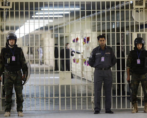 FILE - In this Feb. 21, 2009 file photo, guards stand at a cell block at the renovated Abu Ghraib prison, now renamed Baghdad Central Prison and run by Iraqis in Baghdad, Iraq. Late-night jailbreak attempts at two major prisons outside Baghdad have killed dozens, including at least 25 members of Iraq's security forces who battled militants armed with car bombs, mortars and machine guns, officials said Monday. AP Photo