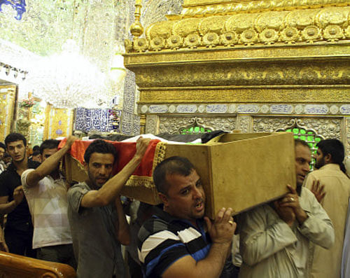 Mourners carry the coffin of a victim killed during an attack on a prison in Taji, during a funeral at the Imam Ali shrine in Najaf, 160 km (100 miles) south of Baghdad July 22, 2013. Sixteen soldiers and six militants were killed during an attack on the prison on Sunday in Taji, around 20 km (12 miles) north of Baghdad, but guards managed to prevent any inmates escaping. The attack was conducted simultaneously and followed a similar pattern as the attack on Abu Ghraib jail, where hundreds of convicts, including senior members of al Qaeda, managed to flee. Picture taken July 22, 2013. REUTERS