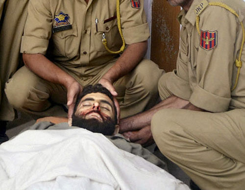 Police men showing the body of top most wanted Commander Qasir Yasir of Jaish-e-Mohammad who was killed in an encounter at Garewad Lolab in Kupwara district on Tuesday. PTI Photo