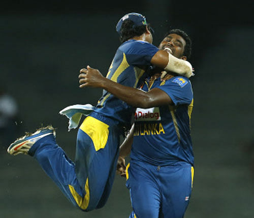 Sri Lankan captain Dinesh Chandimal, left, and bowler Thisara Perera celebrate the dismissal of South African batsman Jean-Paul Dumini, unseen, during their second one-day international cricket match in Colombo, Sri Lanka, Tuesday, July 23, 2013.(AP Photo