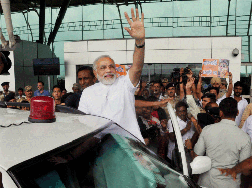 Gujarat Chief Minister Narendra Modi waves on his arrival at Bhubaneswar airport .PTI File Photo