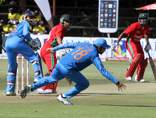 India's captain Virat Kohli, center, attempts to stop the ball during the one day match against Zimbabwe in Harare, Wednesday July 24, 2013. AP Photo