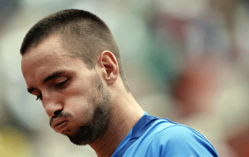 FILE - In this June 2, 2013, file photo, Serbia's Viktor Troicki blows out air as he plays France's Jo-Wilfried Tsonga during their fourth round match of the French Open tennis tournament at the Roland Garros stadium in Paris. Troicki has been suspended for 18 months for refusing to submit to blood testing before the Monte Carlo Masters. AP photo
