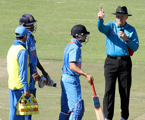 Virat Kohli, second from right, is given a signal to get out after he was caught for 14 runs on the second day of the one day international cricket match against Zimbabwe, in Harare, Zimbabwe Friday, July 26, 2013. (AP Photo