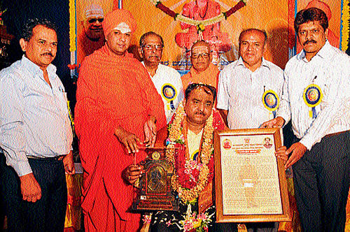 Retired DG and IGP Shankar Bidari receives 'Basavasri award,' in Mysore, on Sunday. Muralegavi Mutt seer Mummadi Shivarudra Swamiji, C P Basavaraj, Former GM BEML, Hosamut seer Chidananda Swamiji, writer Malali Vasanthkumar and B S Tandavamurthy are seen. dh photo