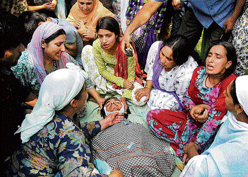 agony:  Relatives wail over the death of a Special Police Officer Mudssir Ahmad Dar who was gunned down by militants at Unto Hamam  in Sopore town of north Kashmir on Sunday. pti