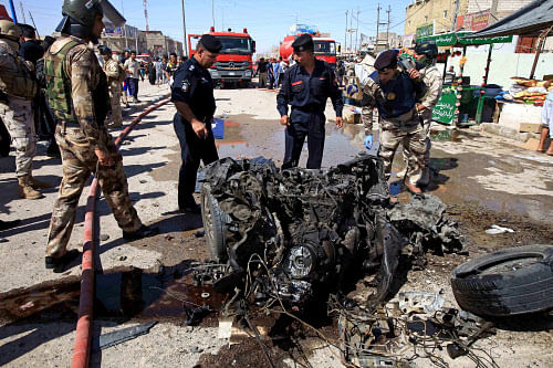 Iraqi security forces inspects wreckage at the site of a car bomb explosion in Basra, 340 miles (550 kilometers) southeast of Baghdad, Iraq, Monday, July 29, 2013. A wave of over a dozen car bombings hit central and southern Iraq during morning rush hour on Monday, officials said, killing scores in the latest coordinated attack by insurgents determined to undermine the government. (AP Photo)