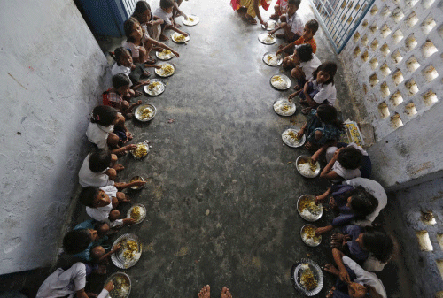 School children eat free mid-day meal, distributed by government-run primary school, at Brahimpur village in Chapra. Reuters