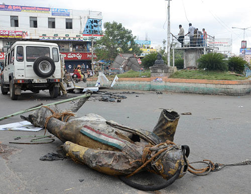 A statue of  former prime minister Rajiv Gandhi lies on a road after being vandalized by anti Telangana protestors in Ananthapur in Andhra Pradesh, Wednesday, July 31, 2013. (AP Photo)