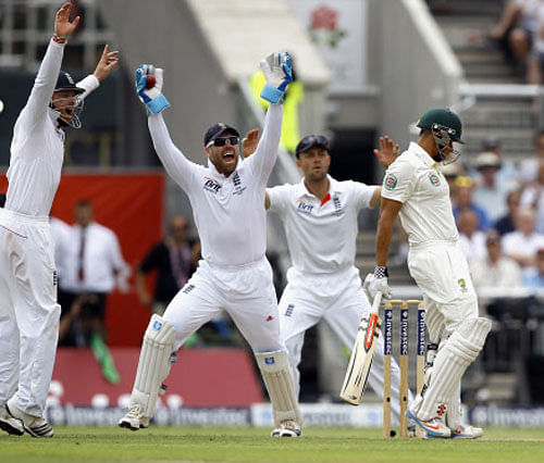Australia's Usman Khawaja, right, reacts after being bowled LBW by England's Graeme Swann during day one of the third Ashes Test match held at Old Trafford cricket ground in Manchester, England, Thursday, Aug. 1, 2013. AP Photo