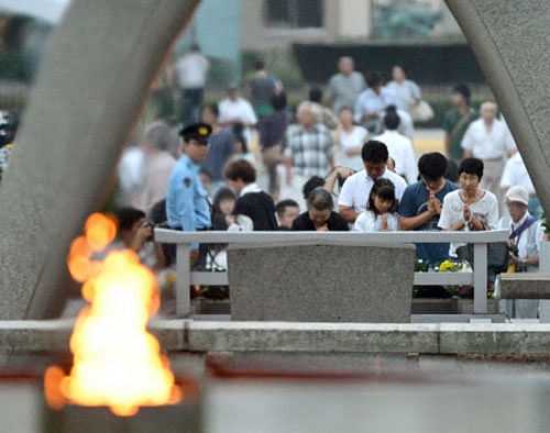 People pray for the atomic bomb victims in front of the cenotaph at the Hiroshima Peace Memorial Park in Hiroshima, western Japan, early Tuesday, Aug. 6, 2013. Japan marked the 68th anniversary Tuesday of the atomic bombing of Hiroshima with a somber ceremony to honor the dead and pledges to seek to eliminate nuclear weapons. AP Photo