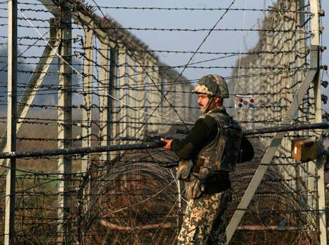 A Border Security Force (BSF) soldier patrols near the fenced border with Pakistan. File PTI Image