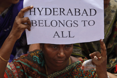 An Andhra Pradesh state government employee holds a placard during a protest against the move to carve out a new state out of the existing state in Hyderabad, India, Tuesday, Aug. 13, 2013. India's ruling coalition recently endorsed the creation of a new state called Telangana to be carved out of Andhra Pradesh state. The opposition to the new state is primarily because the proposed Telangana area would include Hyderabad, the state capital and industrial hub. AP photo