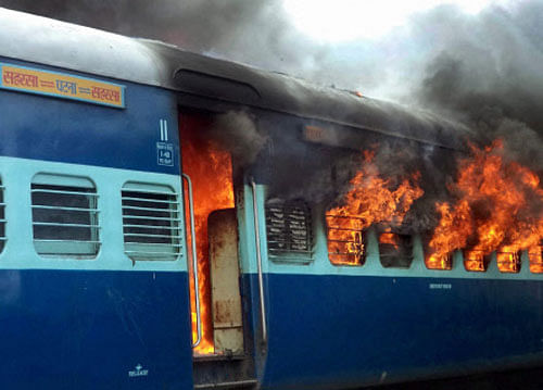 Burning train:  Angry people set ablaze Rajya Rani Express train after it ran over pilgrims at Dhamara railway station in Khagaria on Monday. PTI