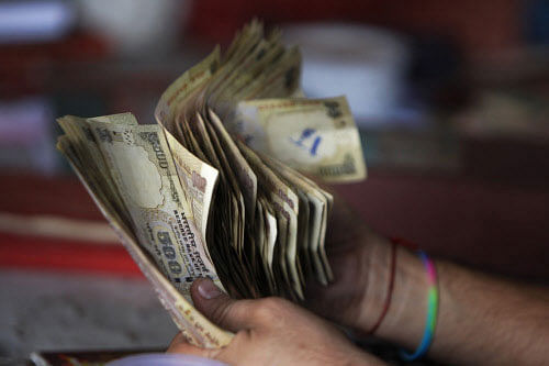 An indian trader counts Rupee currency at a wholesale market in Jammu, India, Monday, Aug.19, 2013. The Indian rupee fell to a record low against the dollar Monday despite the measures to curb its decline. India recently tightened restrictions on the amount of money Indian companies and individuals can send out of the country, trying to curb a sharp decline in the rupee. The U.S. dollar has risen about 15 percent against the Indian rupee this year, pushing up costs for oil and other crucial imports, amid stagnating economic growth. (AP Photo