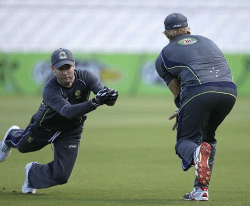 Australia's captain Michael Clarke, left, takes the ball watched by Shane Watson during a nets session for the 5th Ashes cricket Test at the Oval cricket ground in London, Monday, Aug. 19, 2013. The 5th test starts Wednesday at the Oval in London, England have already won the series and retained the Ashes. AP Photo.