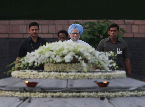 Prime Minister Manmohan Singh, center, pays tributes to former Indian Prime Minister Rajiv Gandhi on his birth anniversary at his memorial in New Delhi, India, Tuesday, Aug. 20, 2013. Rajiv Gandhi was killed in a suicide bomb attack on May 21, 1991 in Tamil Nadu state during a poll campaign. AP Photo.