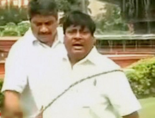 Telugu Desam Party MP Naramalli Sivaprasad whipping himself outside the Parliament in New Delhi on Thursday in protest against the bifurcation of Andhra Pradesh. PTI Photo