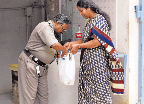 cautious: The security personnel checks the bags of the maids when they enter and leave the apartment block at Harmony Homes in Kalyan Nagar.