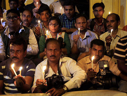 Photo journalists during a candle light vigil to protest against rape of a woman photo journalist in Mumbai, in Lucknow on Friday. PTI Photo