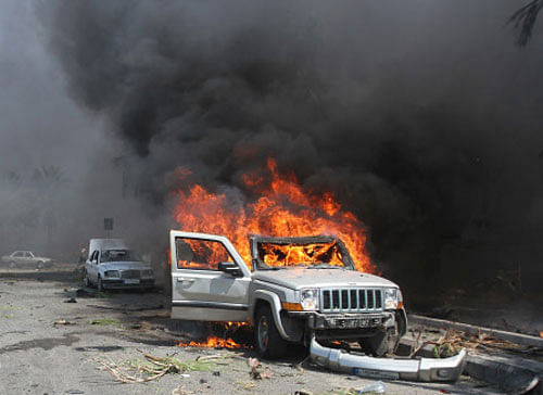 A car burns outside one of two mosques hit by explosions in Lebanon's northern city of Tripoli, August 23, 2013. Twin explosions hit two mosques in the northern Lebanese city of Tripoli on Friday, killing at least 42 people and wounding hundreds, intensifying the sectarian strife that has spilled over from the civil war in neighbouring Syria. REUTERS