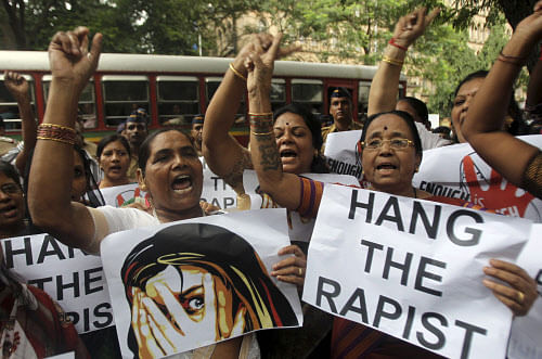 Activists hold placards and shout slogans as they protest against the gang rape of a 22-year-old woman photojournalist in Mumbai India, Friday, Aug 23, 2013. The woman was gang raped while her male colleague was tied up and beaten in an isolated, overgrown corner of India's business hub of Mumbai, police said Friday. (AP Photo)