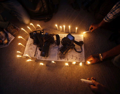 Journalists place candles around cameras protesting against the gang rape of a young photojournalist, during a candle light vigil in Bangalore on Saturday, Aug. 24, 2013. Police on Saturday arrested a third man and said they had enough evidence to prosecute those responsible for a crime that has renewed public outcry over sexual violence in the country. The victim, a 22-year-old woman, remained in a hospital Saturday and was recovering well after being repeatedly raped by five men Thursday night in a deserted textile mill, said Mumbai's police commissioner, Satyapal Singh. AP Photo