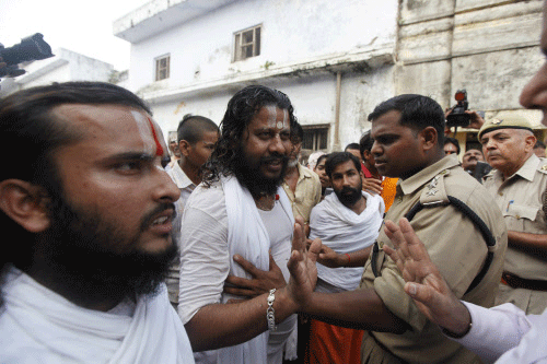 Policemen stop activists of the nationalist organization Vishva Hindu Parishad (VHP) or World Hindu Council in Ayodhya, about, 550 kilometers (350 miles) east of New Delhi, India, Sunday, Aug. 25, 2013. Authorities on Sunday detained hundreds of Hindu nationalists in northern India for allegedly defying a ban on pilgrimages to a disputed holy site that has been the cause of deadly clashes between Hindus and Muslims.  AP photo