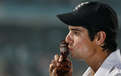 England's captain Alastair Cook kisses the replica Ashes urn after the fifth Ashes test cricket match against Australia ended in a draw and England won the series 3-0 at the Oval cricket ground in London August 25, 2013. REUTERS