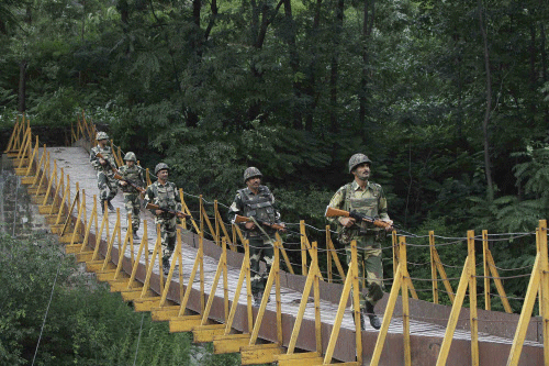 Border Security Force (BSF) soldiers patrol over a footbridge built over a stream near the Line of Control (LoC), a ceasefire line dividing Kashmir between India and Pakistan, at Sabjiyan sector of Poonch district, August 8, 2013. India for the first time directly accused the Pakistan army of involvement in an ambush that killed five Indian soldiers, and hinted on Thursday at retaliation for possibly the worst such attack since the neighbours signed a ceasefire in 2003. REUTERS