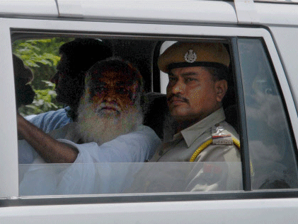 Asaram Bapu is taken away on his arrival at the airport in Jodhpur on Sunday following his arrest from his Indore Ashram in connection with a sexual assault case. PTI Photo