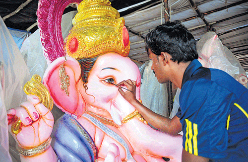 detailed: An artist applies the final touches to an idol at Pottery Town.
