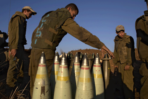Israeli soldiers handle artillery shells in the Golan Heights, near the border between the Israeli-controlled Golan Heights and Syria, Friday, Aug. 30, 2013. AP photo