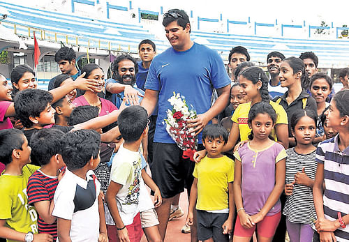 hello superman! India's star discus thrower Vikas Gowda greets aspiring athletes at the Sree Kanteerava Stadium in Bangalore on Tuesday. DH photo