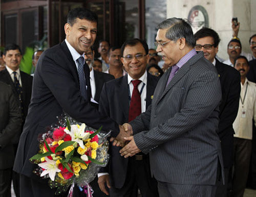 Raghuram Rajan, left, the newly appointed governor of Reserve Bank of India, smiles as he is greeted by its Deputy Governor Kamalesh Chandra Chakrabarty, second right, and others upon his arrival at the RBI headquarters in Mumbai on Wednesday. AP Photo