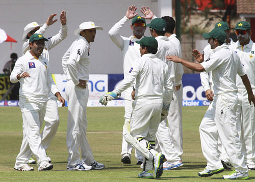 Pakistan players celebrate the wicket of Zimbabwean batsman Tinotenda Mawoyo during the first Test match against Zimbabwe at Harare Sports Club in Harare, Wednesday, Sept, 4, 2013. Pakistan is in Zimbabwe to play Test matches against the hosts. (AP Photo)
