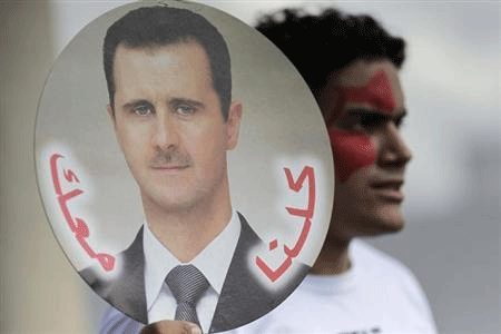 A student holds a sign with a picture of Syria's President Bashar al-Assad during a protest by a students' national union against possible U.S. military action in Syria, in Brasilia September 6, 2013. The sign reads, ''Against Imperialist War, Peace in Syria''. Reuters