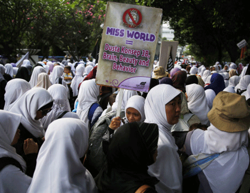 Indonesian Muslim women protesters gather during a protest against the upcoming Miss World pageant in Jakarta, September 5, 2013. Hundreds of Muslim protestors staged a rally in Jakarta to protest against the Miss World pageant which will be held in Bali in September, a local paper reported on Thursday. The placard reads 'Miss World = the lie concept of brain, beauty and behaviour.' REUTERS