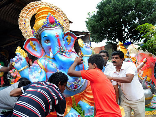 Devotees carrying a huge Ganesha idol in Bangalore. DH Photo by Satish Badiger