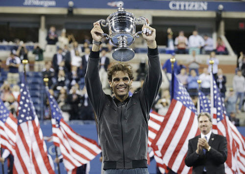 Rafael Nadal, of Spain, holds up the championship trophy after winning the men's singles final over Novak Djokovic, of Serbia,o at the 2013 U.S. Open tennis tournament, Monday, Sept. 9, 2013, in New York. (AP Photo